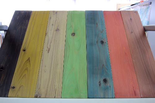 液体ガラスと顔料を同時に加工処理した木材のサンプル。弁柄のような黒系の色（一番左）や白木のような色（左から三番目）の他に、黄色や緑、青、赤系統の色にも着色できる（写真：日経ホームビルダー）