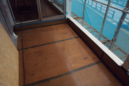 チバ建装が手掛けたバルコニーのFRP防水部分。FRP層の施工後、表面塗装は完成直前まで待つ。FRP層や、下地板の継ぎ目に張った防水テープなどの施工状態などがひと目で確認できる（写真：池谷和浩）